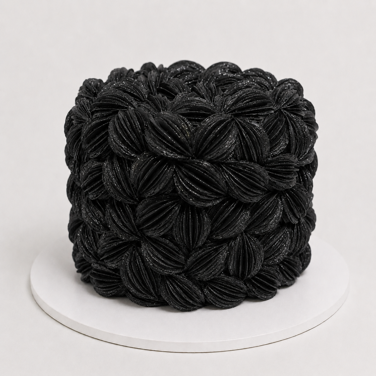 Luxury black wafer paper petal statement cake with textured floral wafer paper design on a white cake board