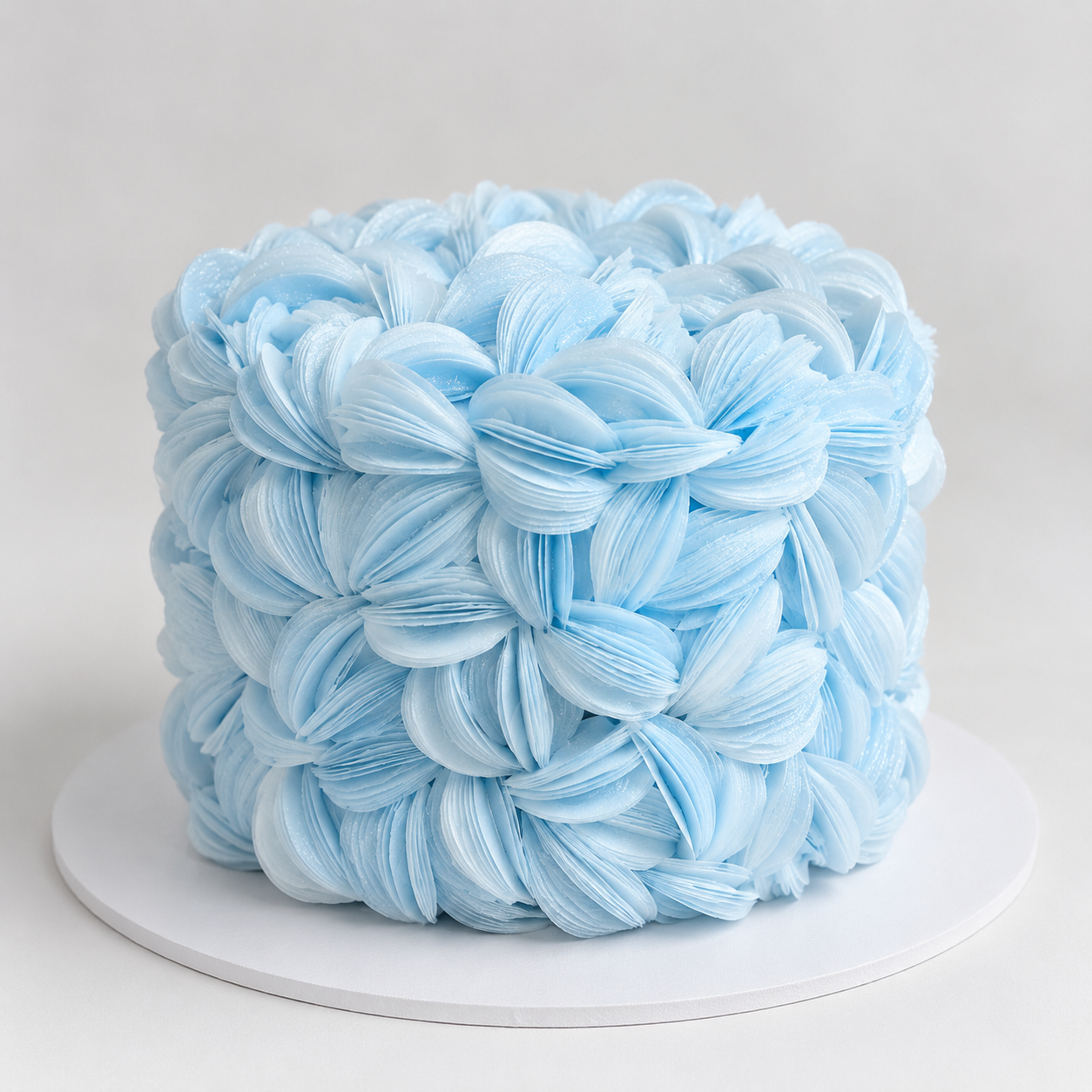 Luxury blue wafer paper petal statement cake with textured floral wafer paper design on a white cake board