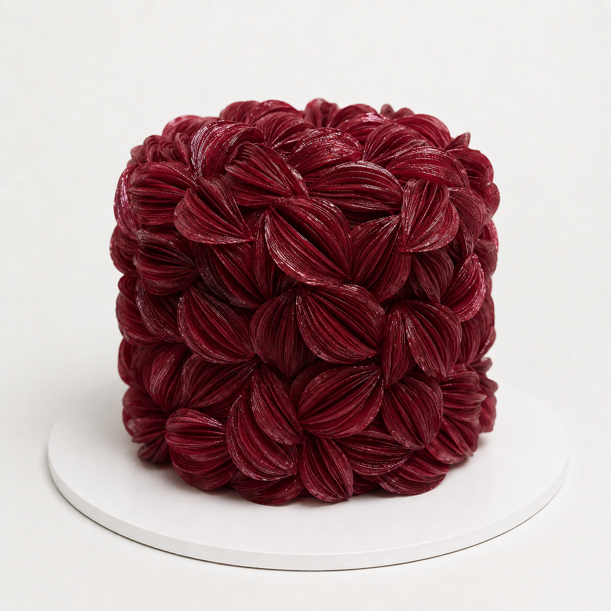 Luxury burgundy wafer paper petal statement cake with textured floral wafer paper design on a white cake board