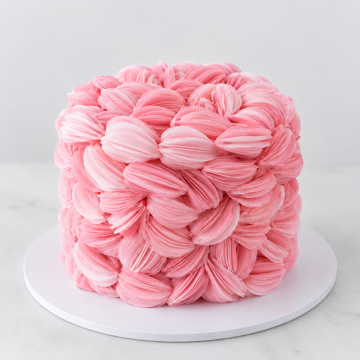 Luxury pink wafer paper petal statement cake with textured floral wafer paper design on a white cake board