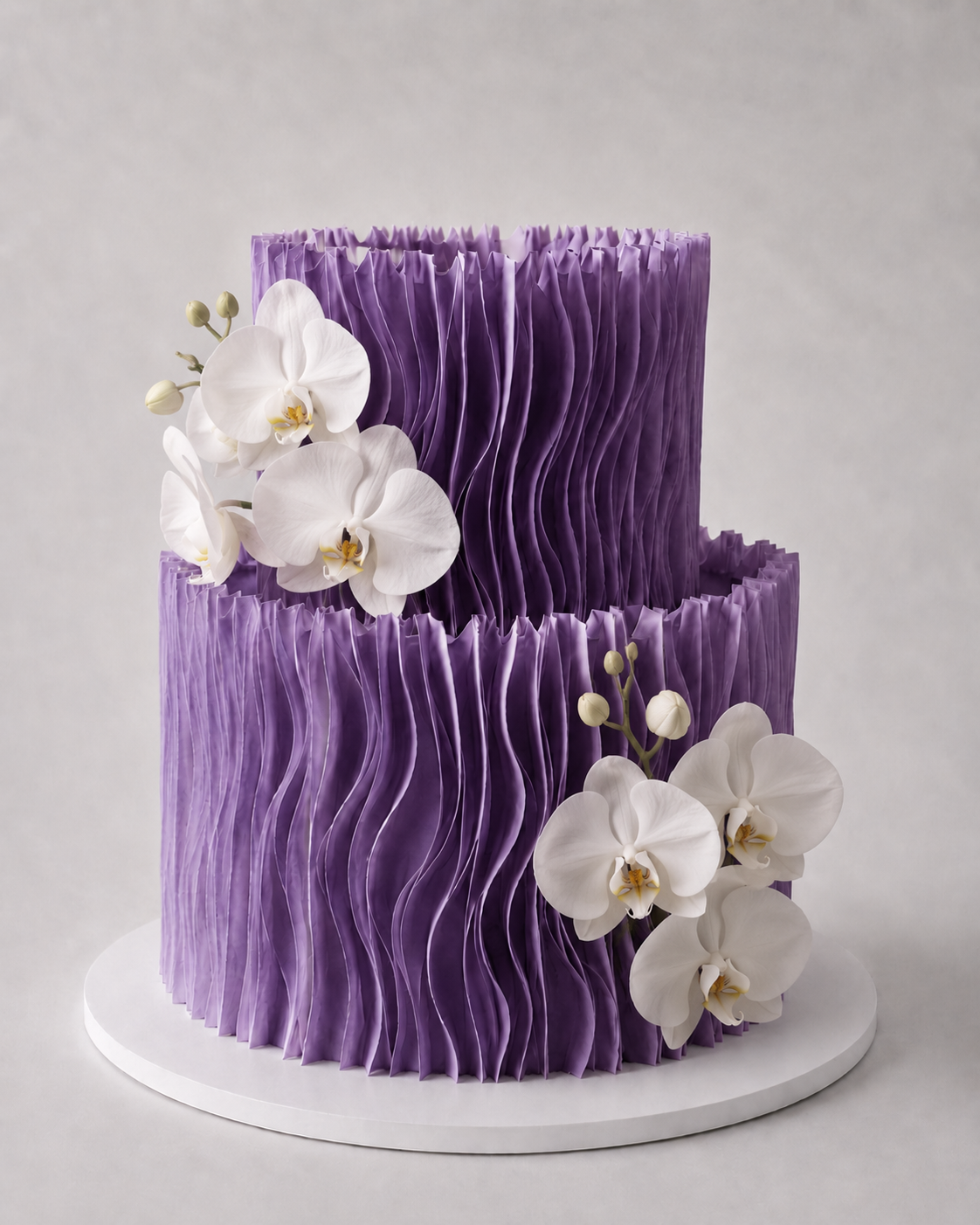 Luxury two-tier purple wafer paper ruffle cake with white orchid flower cluster on a white cake board